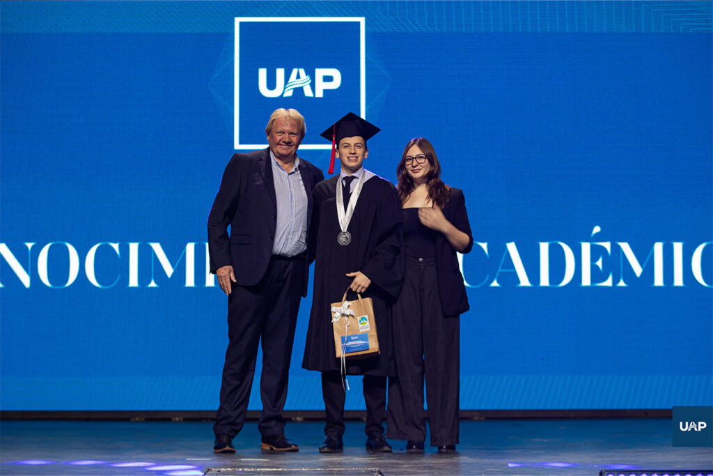 Darío Heinze, intendente de Libertador San Martín, entregando una distinción especial a los graduados que realizaron toda su formación académica en esta localidad.